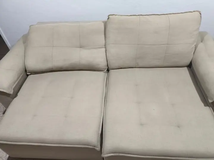 O mesmo sofá bege depois da limpeza, com o tecido uniforme e sem as marcas no assento
